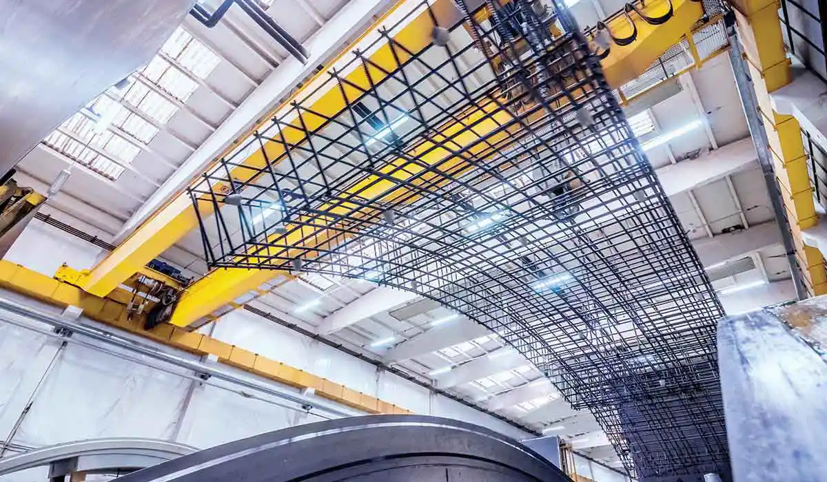 Curved reinforcement mesh cage bent to the design radius, hoisted in the workshop for automated production of tunnel/arch segments